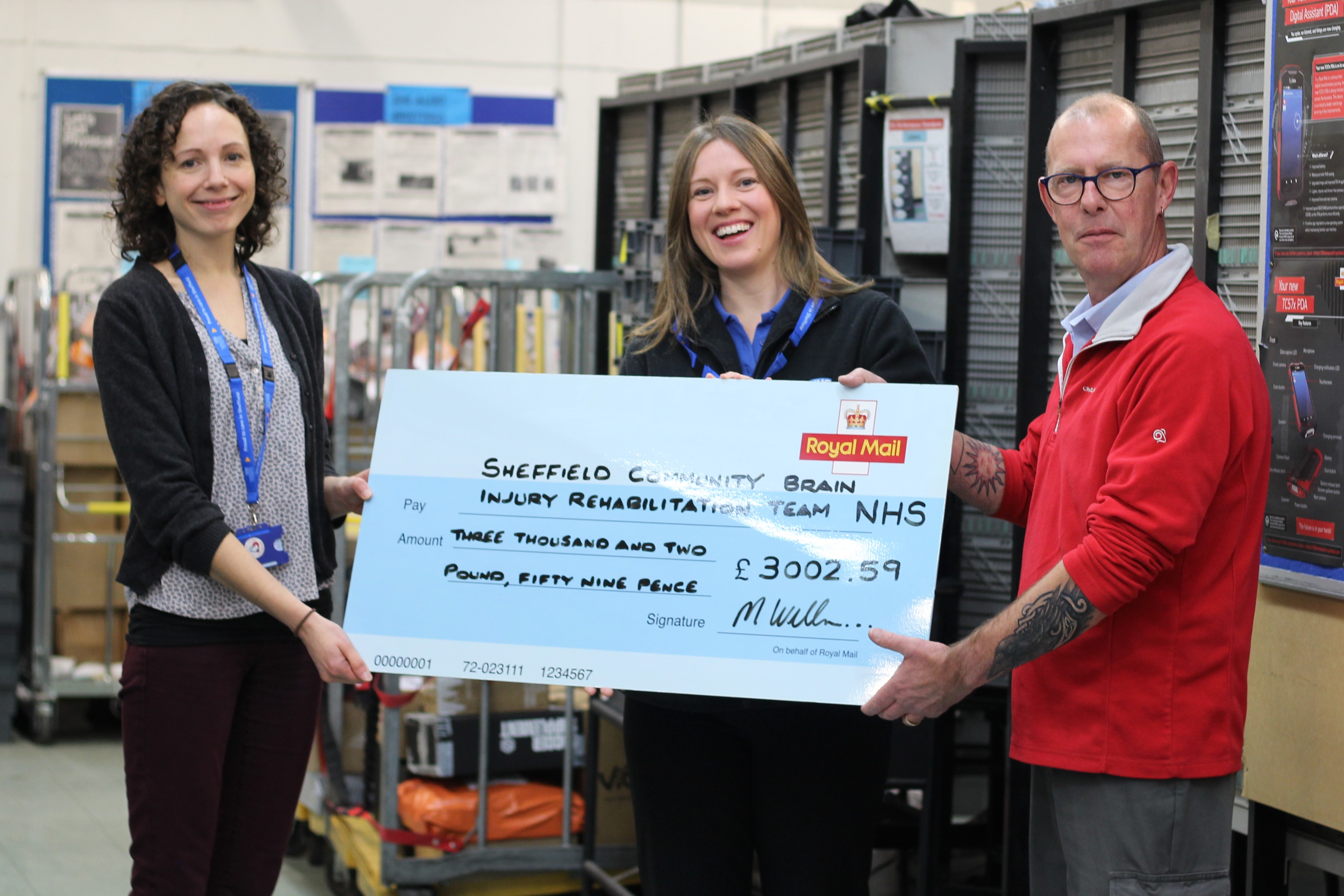 Sarah Morrey and Lucy Needham from SCBIRT receive the cheque from Iain Barker in front of his colleagues