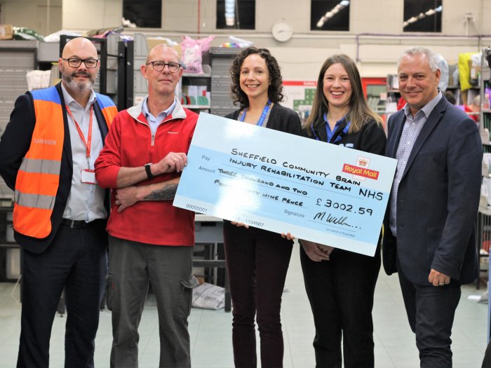 SCBIRT staff receiving cheque from Royal Mail fundraisers