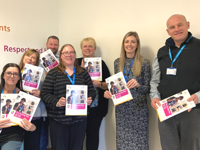 Nursing leadership team holding copies of the nursing plan