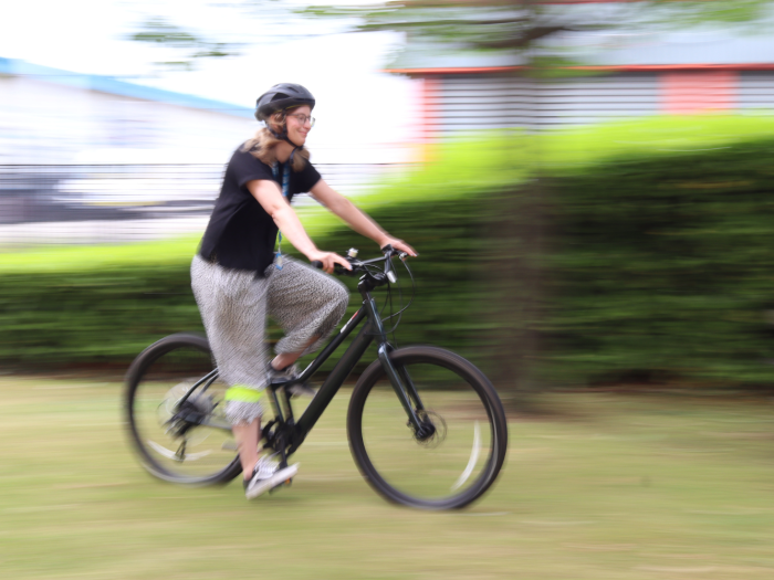Cyclist on an e-bike moving blurrily from left to right