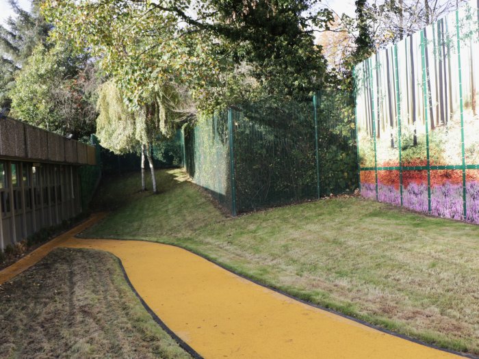 Burbage ward garden with grass either side of a yellow path and a tree in the distance