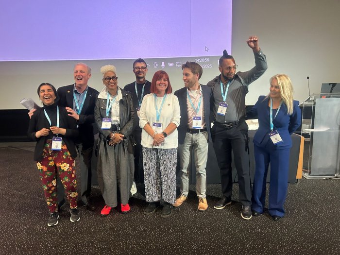 People on stage grouped together for a photo at a conference