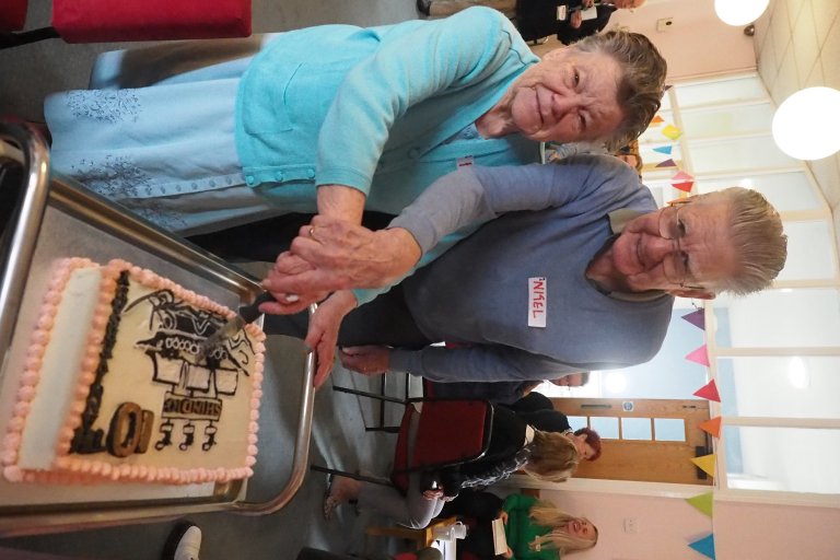 Service users cutting a celebratory cake