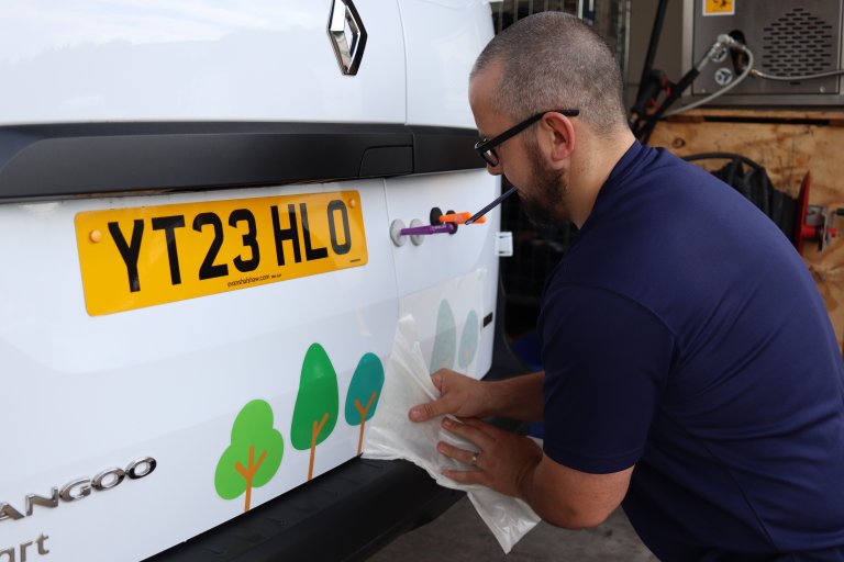 Person applying livery to white van