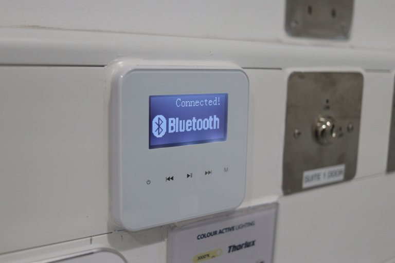 Bluetooth connector panel on a wall shows a signal is connected