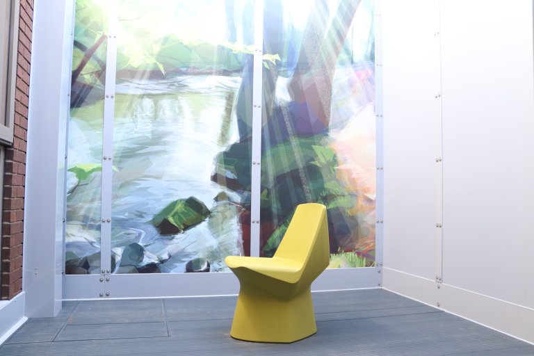 Courtyard area showing fencing with artwork on display and a chair on the floor