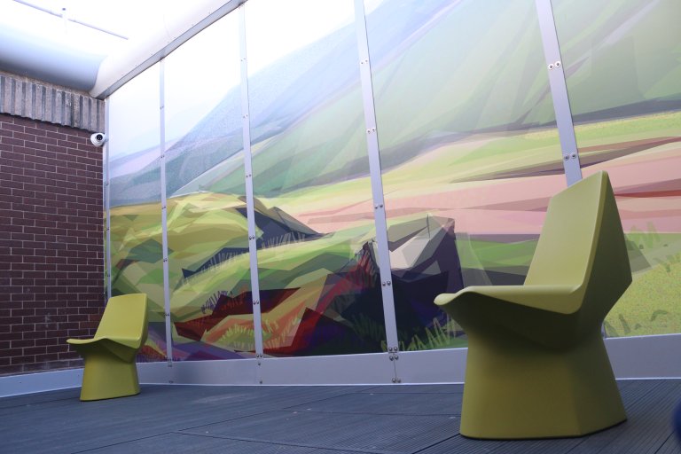 Courtyard with artwork on walls and two chairs