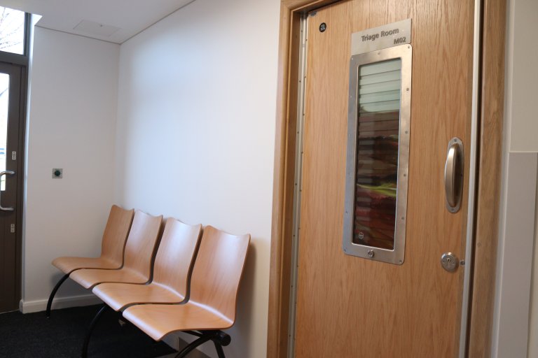 Four chairs alongside a door