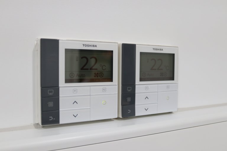 Two thermostats on a wall