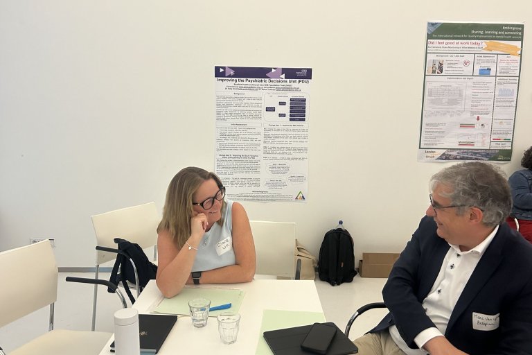 People sat talking round a table at a conference
