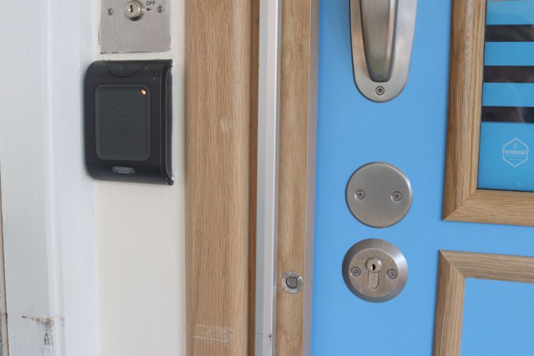Bright blue bedroom door with keyhole and fob access